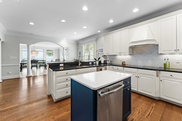 kitchen featuring kitchen peninsula, stainless steel dishwasher, sink, white cabinets, and a center island