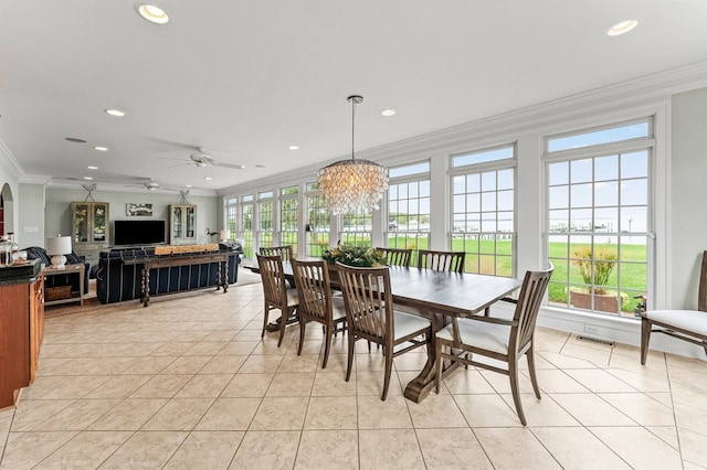 tiled dining room with ceiling fan with notable chandelier and ornamental molding