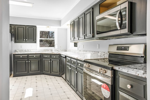 kitchen featuring light stone counters, stainless steel appliances, a sink, ornamental molding, and light floors