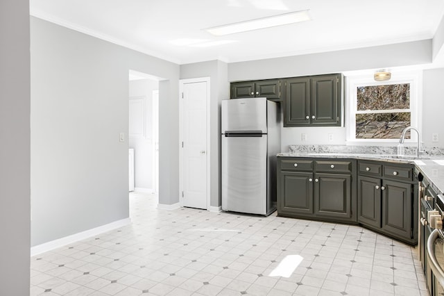 kitchen with light floors, ornamental molding, a sink, and freestanding refrigerator