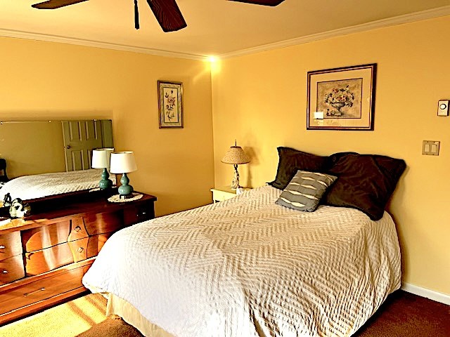 bedroom with crown molding, carpet floors, and ceiling fan