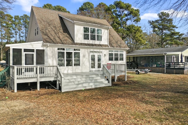 back of house with french doors, roof with shingles, a deck, and a sunroom