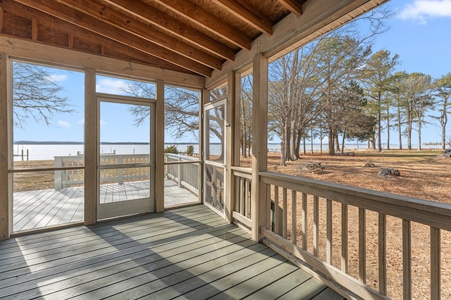 unfurnished sunroom featuring a water view