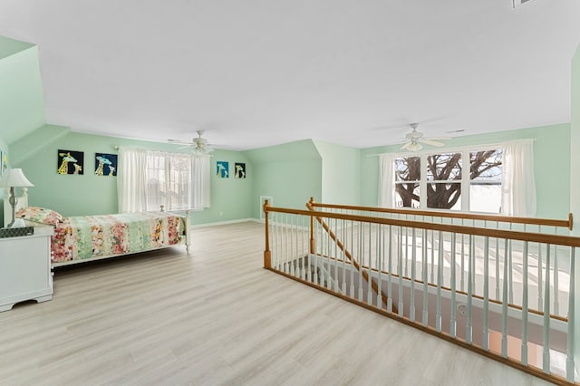 bedroom featuring lofted ceiling, wood finished floors, and a ceiling fan