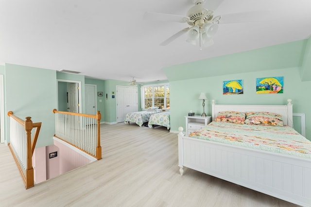 bedroom featuring ceiling fan, visible vents, baseboards, and wood finished floors