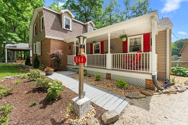 844 Monarch Shores Rd, Kilmarnock, VA 22482 - view of front of home with covered porch, a shingled roof, a gambrel roof, and brick siding