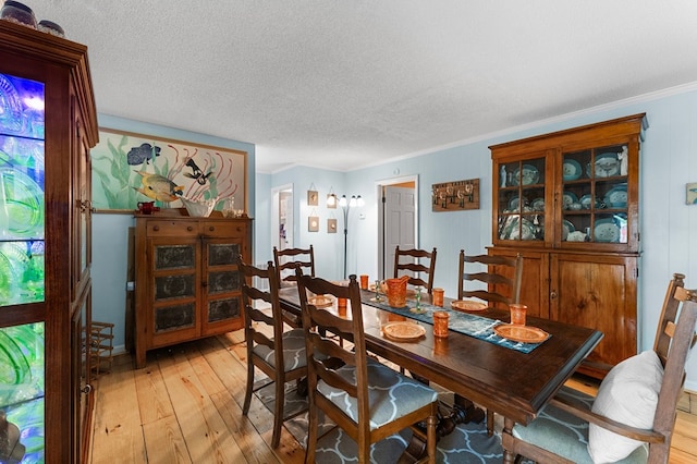 844 Monarch Shores Rd, Kilmarnock, VA 22482 - dining space featuring light wood finished floors, a textured ceiling, and ornamental molding