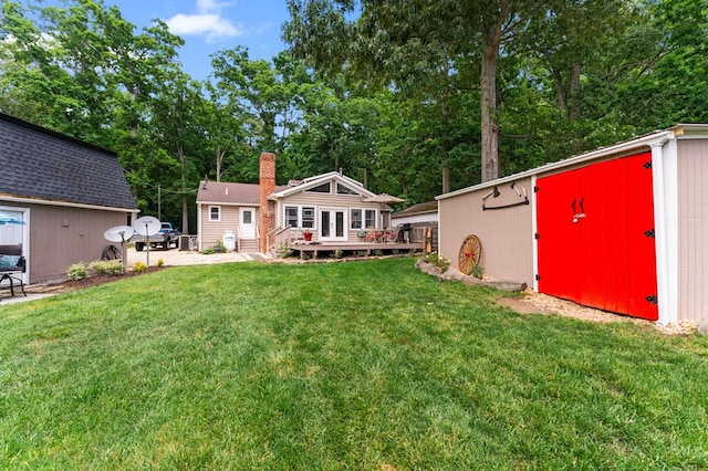 844 Monarch Shores Rd, Kilmarnock, VA 22482 - view of grassy yard with an outbuilding, a wooden deck, and view of wooded area