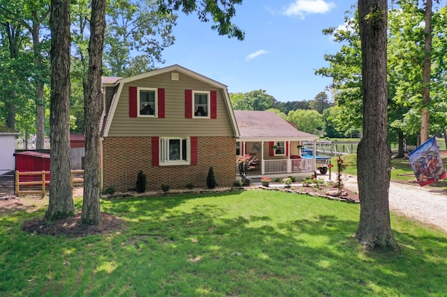 844 Monarch Shores Rd, Kilmarnock, VA 22482 - dutch colonial with a gambrel roof, brick siding, a front yard, a porch, and an outbuilding