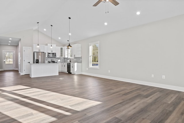 unfurnished living room with high vaulted ceiling, sink, dark hardwood / wood-style floors, and ceiling fan