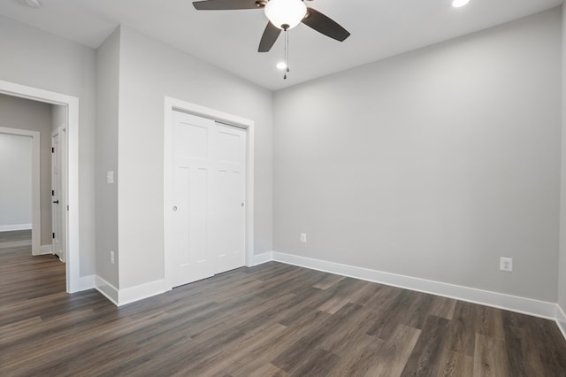 unfurnished bedroom featuring ceiling fan, a closet, and dark hardwood / wood-style flooring