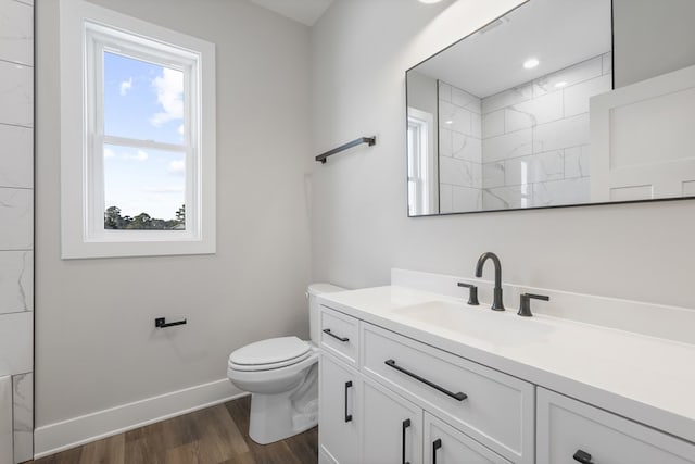 bathroom with toilet, a shower, hardwood / wood-style flooring, and vanity