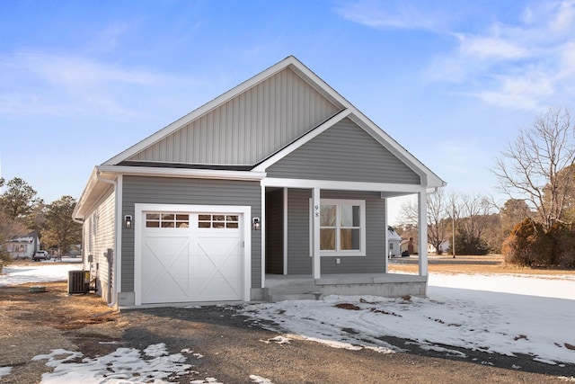 view of front of property with a garage, a porch, and central air condition unit