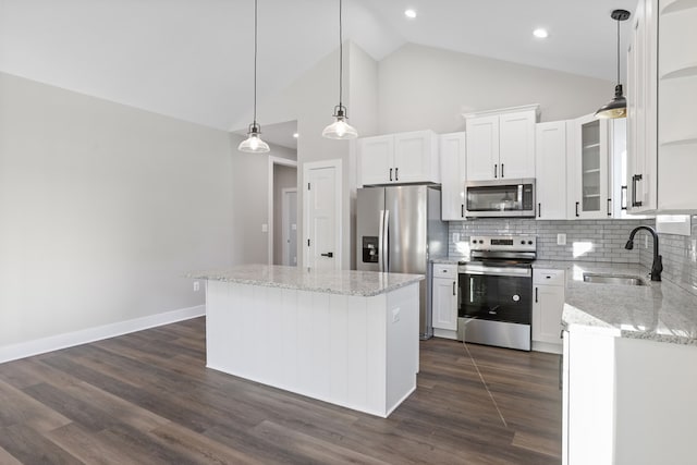 kitchen featuring a kitchen island, decorative backsplash, sink, stainless steel appliances, and white cabinets