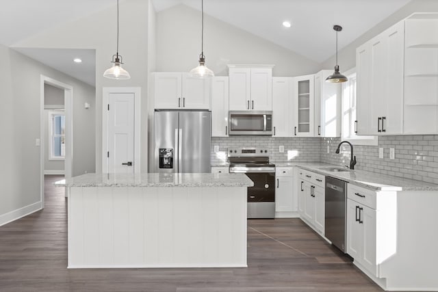 kitchen with white cabinets, sink, stainless steel appliances, and a kitchen island