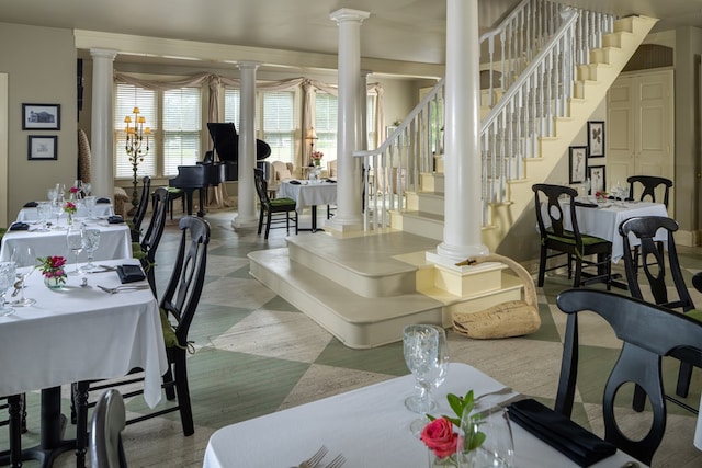 dining room with ornate columns and an inviting chandelier