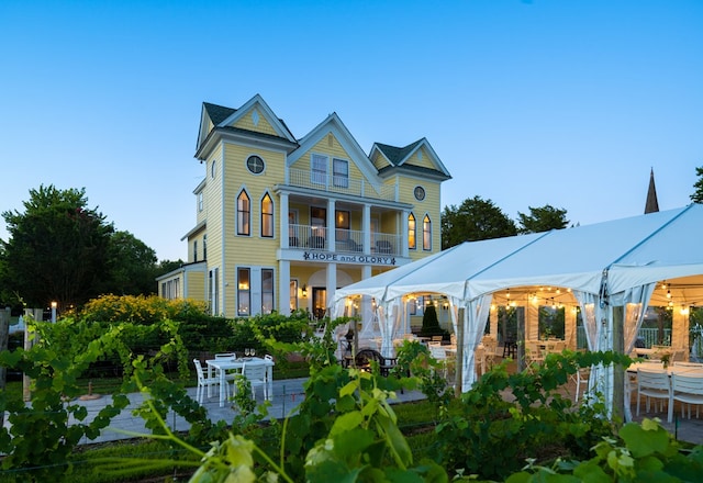 rear view of property featuring a gazebo and a balcony