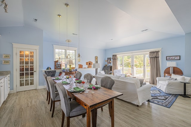 dining room with light hardwood / wood-style floors and lofted ceiling