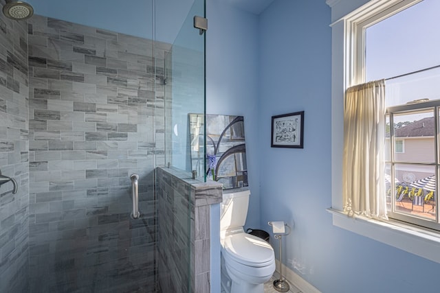 bathroom with walk in shower, a healthy amount of sunlight, and toilet