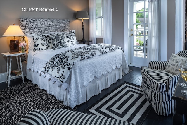 bedroom with dark hardwood / wood-style floors and multiple windows