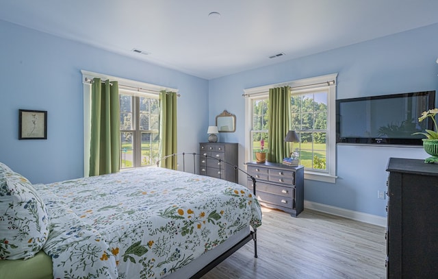 bedroom featuring light hardwood / wood-style floors and multiple windows