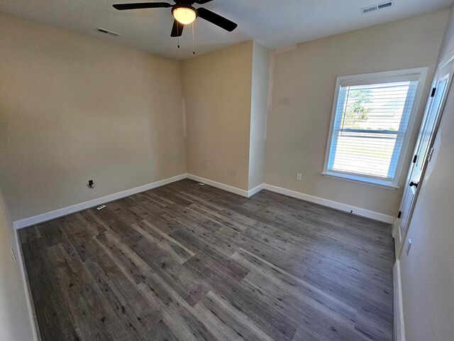 spare room with ceiling fan, a healthy amount of sunlight, crown molding, and dark hardwood / wood-style flooring