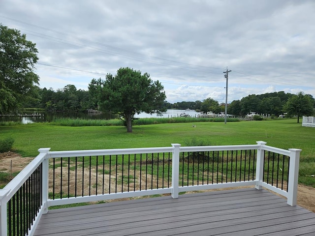 wooden terrace featuring a water view and a yard