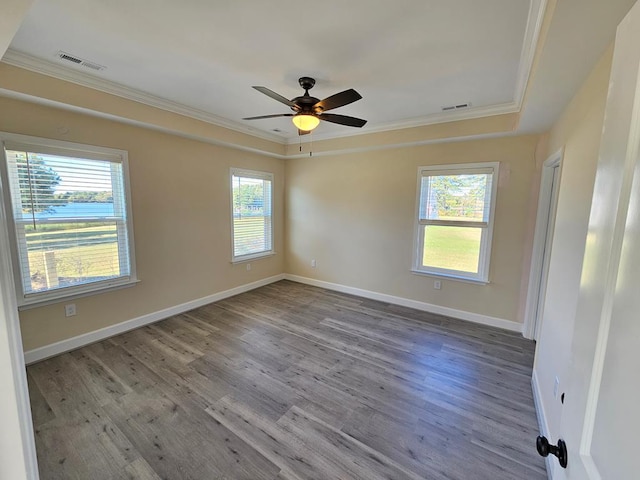 empty room featuring ornamental molding, a healthy amount of sunlight, and light hardwood / wood-style flooring