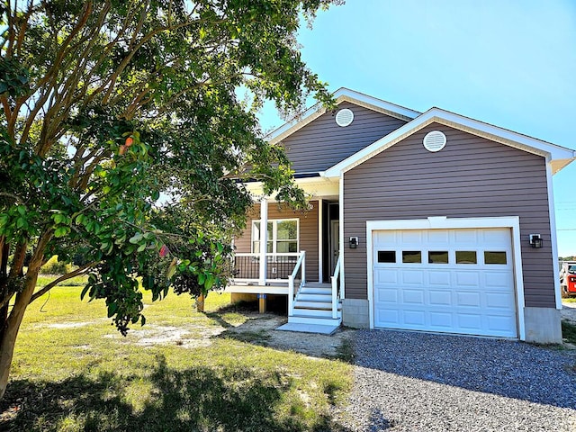 view of front of home featuring covered porch, a front yard, driveway, and an attached garage