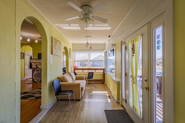 sunroom with a fireplace and ceiling fan