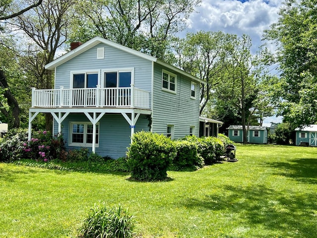 rear view of property featuring a chimney and a lawn