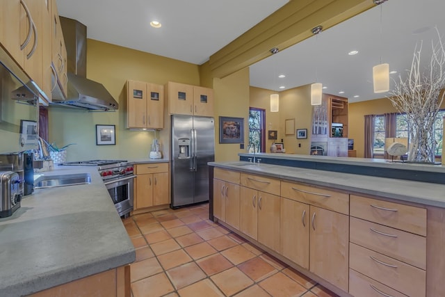 783 King Carter Dr, Irvington, VA 22480 - kitchen featuring wall chimney exhaust hood, stainless steel appliances, light brown cabinets, hanging light fixtures, and light tile patterned flooring
