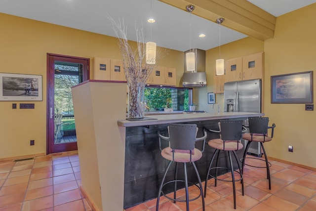 783 King Carter Dr, Irvington, VA 22480 - kitchen with wall chimney exhaust hood, decorative light fixtures, light tile patterned flooring, stainless steel fridge with ice dispenser, and a breakfast bar area