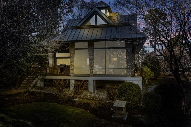 783 King Carter Dr, Irvington, VA 22480 - back house at dusk featuring a sunroom