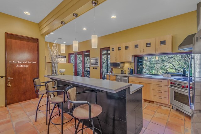 783 King Carter Dr, Irvington, VA 22480 - kitchen with a center island, sink, light brown cabinetry, decorative light fixtures, and stainless steel appliances