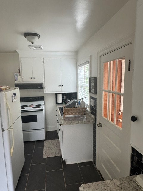 2266 Hayes Rd, Hayes, VA 23072 - kitchen with white appliances, white cabinets, dark tile patterned flooring, and under cabinet range hood