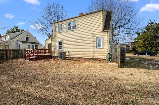 rear view of property featuring a wooden deck and central AC