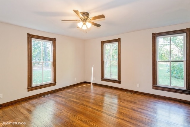 spare room featuring ceiling fan, plenty of natural light, and hardwood / wood-style flooring