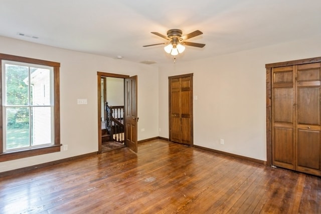 empty room featuring ceiling fan and dark wood-type flooring