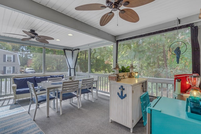 sunroom with ceiling fan and beamed ceiling