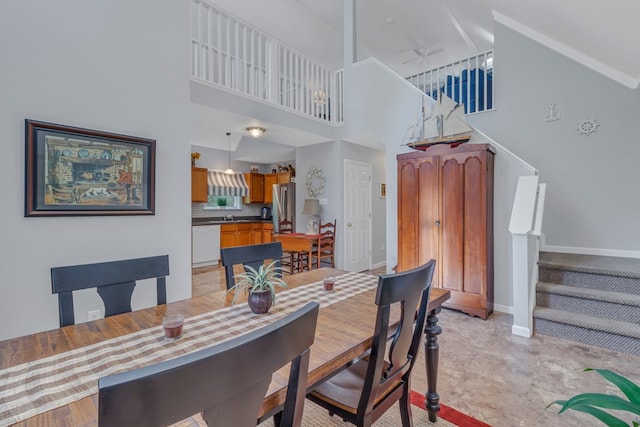 dining area with ceiling fan and a high ceiling