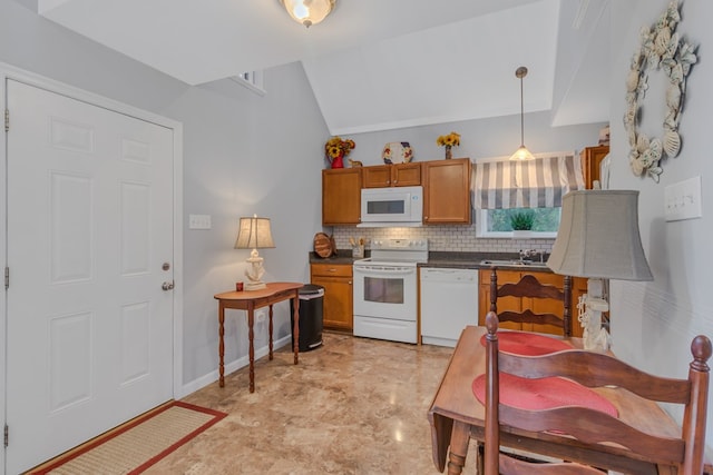 kitchen featuring tasteful backsplash, white appliances, vaulted ceiling, sink, and decorative light fixtures