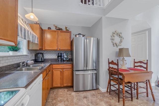 kitchen featuring stainless steel fridge, tasteful backsplash, sink, decorative light fixtures, and dishwasher