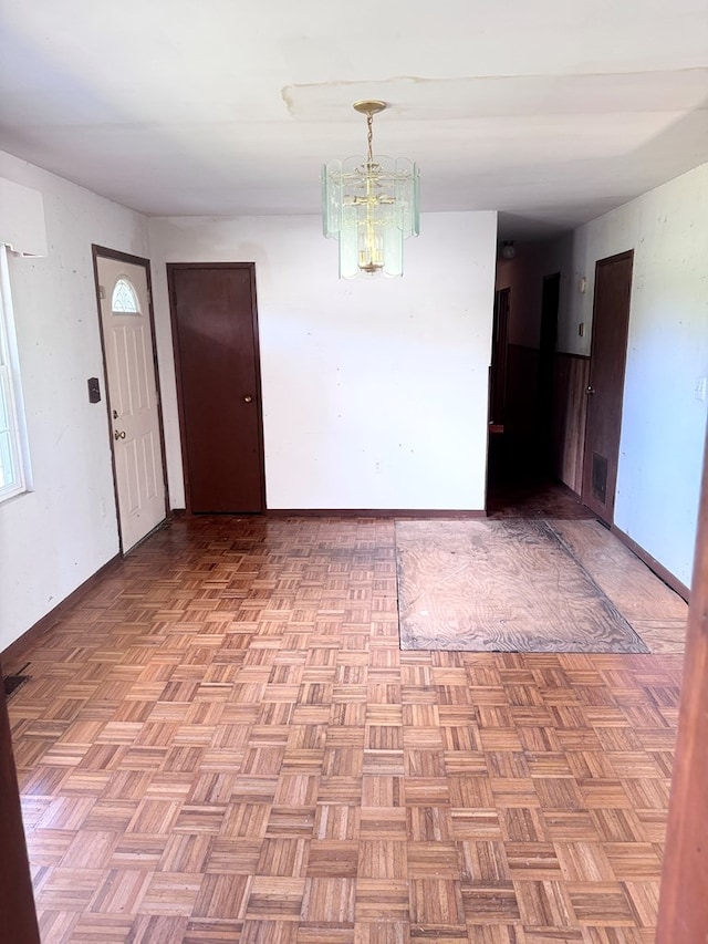 unfurnished room with visible vents and an inviting chandelier