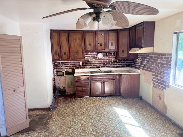 kitchen featuring ceiling fan, a sink, baseboards, light countertops, and tile patterned floors