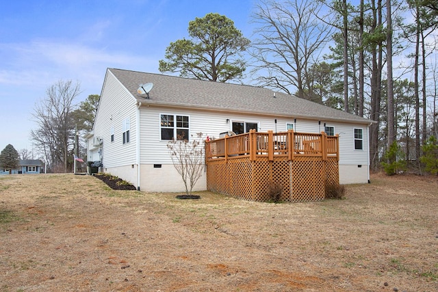 back of house with crawl space, a deck, and roof with shingles