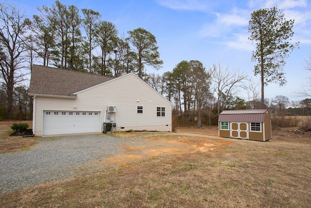 view of side of home featuring an outbuilding, gravel driveway, roof with shingles, crawl space, and a shed