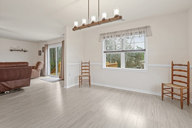 living area with plenty of natural light, baseboards, and wood finished floors