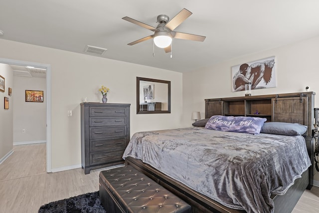 bedroom featuring visible vents, ceiling fan, light wood-style flooring, and baseboards