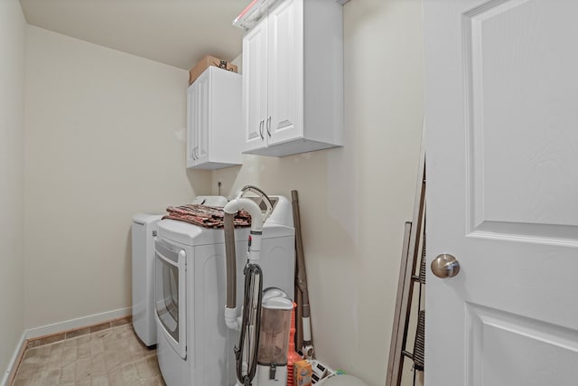 laundry room featuring washer and dryer, cabinet space, and baseboards